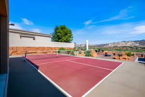 View of tennis court featuring a patio area and a mountain view