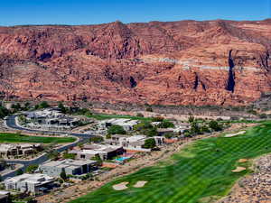 Aerial view of property and surrounding area with a golf club and a mountainous background