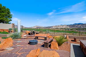 View of patio with a mountain view, a fire pit, and outdoor dining space