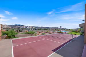 View of tennis court with a mountain view and community basketball court