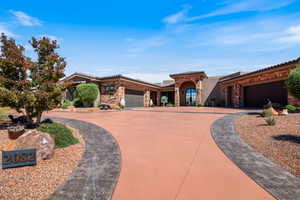 Mediterranean / spanish-style house featuring stone siding, a garage, driveway, stucco siding, and a tiled roof