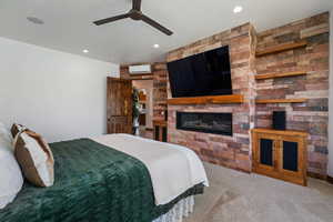 Carpeted bedroom with a glass covered fireplace, recessed lighting, and ceiling fan