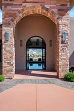 Property entrance featuring stucco siding and stone siding
