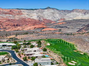 Aerial overview of property's location featuring a local golf course, a mountainous background, and nearby suburban area