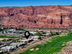 Aerial view of property and surrounding area with a local golf course and mountains