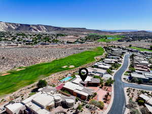 Aerial view of residential area with a mountain backdrop and a golf club