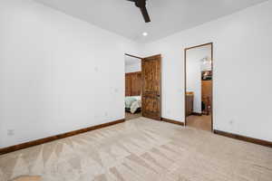 Unfurnished bedroom featuring recessed lighting, carpet flooring, a ceiling fan, and ensuite bath