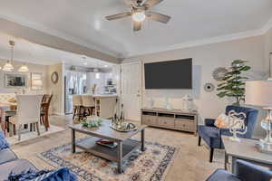 Living area featuring ornamental molding, a ceiling fan, and light colored carpet