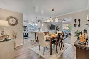 Dining room featuring crown molding, light wood-style floors, a ceiling fan, and recessed lighting