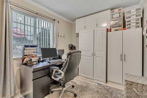 Office area with ornamental molding, light tile patterned flooring, and a textured ceiling