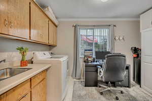 Laundry room with crown molding, an office area, a textured ceiling, cabinet space, and washing machine and clothes dryer