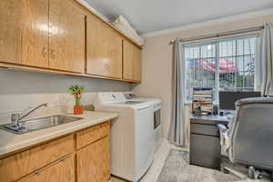 Washroom with a desk, ornamental molding, separate washer and dryer, a textured ceiling, and light tile patterned floors