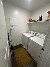 Laundry area with dark wood-style floors and independent washer and dryer