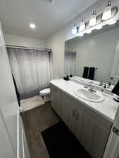 Bathroom with dark wood-style floors, vanity, a textured ceiling, and recessed lighting