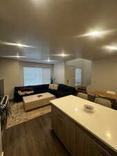 Living area featuring dark wood-style floors and baseboards