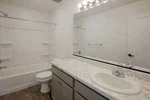 Bathroom featuring bathing tub / shower combination, vanity, and dark wood-style floors
