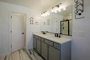Full bathroom with double vanity and a stall shower