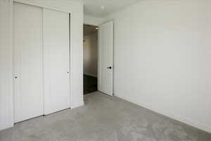 Unfurnished bedroom with carpet flooring and a closet
