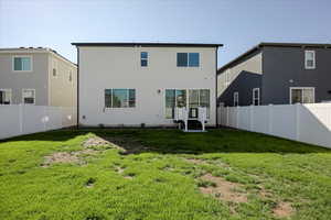 Back of house with a fenced backyard and stucco siding