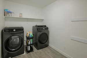 Laundry room featuring light wood-style floors and independent washer and dryer