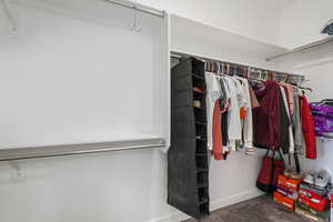 Walk in closet featuring dark colored carpet