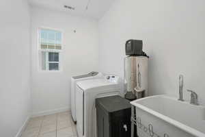 Laundry room with light tile patterned floors and separate washer and dryer