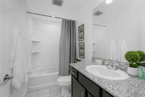 Bathroom with shower / bath combination with curtain, light tile patterned flooring, and vanity