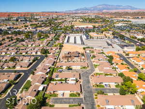 Aerial view of property and surrounding area with nearby suburban area and a mountainous background