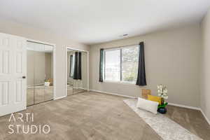 Unfurnished bedroom featuring two closets and carpet