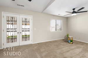 Empty room featuring a ceiling fan, french doors, carpet flooring, and a textured ceiling