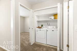 Washroom with carpet, independent washer and dryer, and a textured ceiling