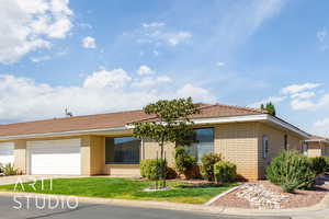 Ranch-style house with brick siding, driveway, a front yard, and a garage