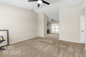 Unfurnished living room with vaulted ceiling, carpet flooring, french doors, and ceiling fan