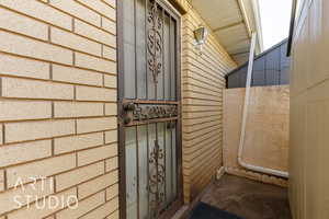 View of exterior entry featuring brick siding