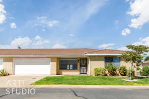 Ranch-style house featuring concrete driveway, a front lawn, brick siding, and a garage