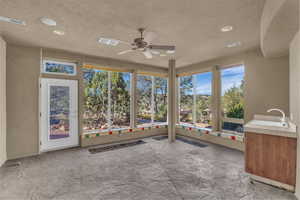 Unfurnished sunroom with a textured ceiling, recessed lighting, and plenty of natural light