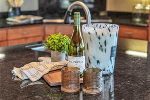Kitchen view of dark stone countertops and brown cabinetry