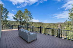 Deck featuring a wooded view, an outdoor hangout area, and a mountain view