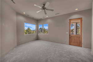 Unfurnished room featuring carpet floors, ceiling fan, and recessed lighting