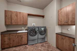 Laundry area with cabinet space, dark stone finish flooring, and independent washer and dryer
