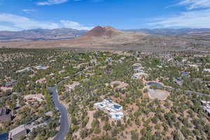 Aerial overview of property's location with a mountainous background and nearby suburban area