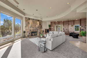 Living area featuring carpet flooring, a stone fireplace, recessed lighting, and built in features