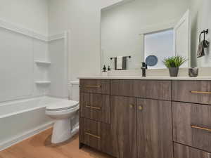 Bathroom featuring vanity, light wood-type flooring, and washtub / shower combination