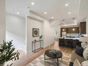 Living area featuring light wood finished floors and recessed lighting