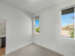Spare room featuring baseboards and light carpet