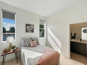 Bedroom featuring light carpet and connected bathroom