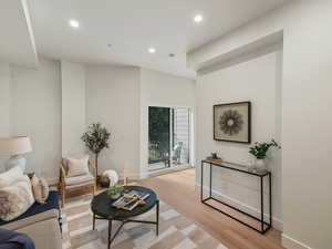 Living area with light wood-style floors and recessed lighting
