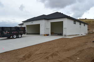 View of side of home with driveway and an attached garage