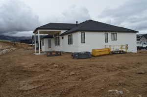 Back of property featuring a patio area and roof with shingles