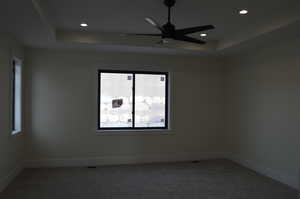 Unfurnished room with a raised ceiling, carpet flooring, ceiling fan, and recessed lighting